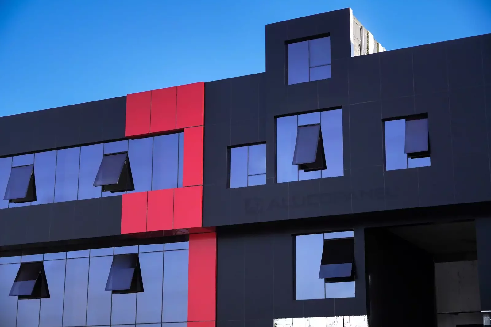 Red accent column and black facade with window louvres, ALUCOPANEL FR, Umm Al Quwain